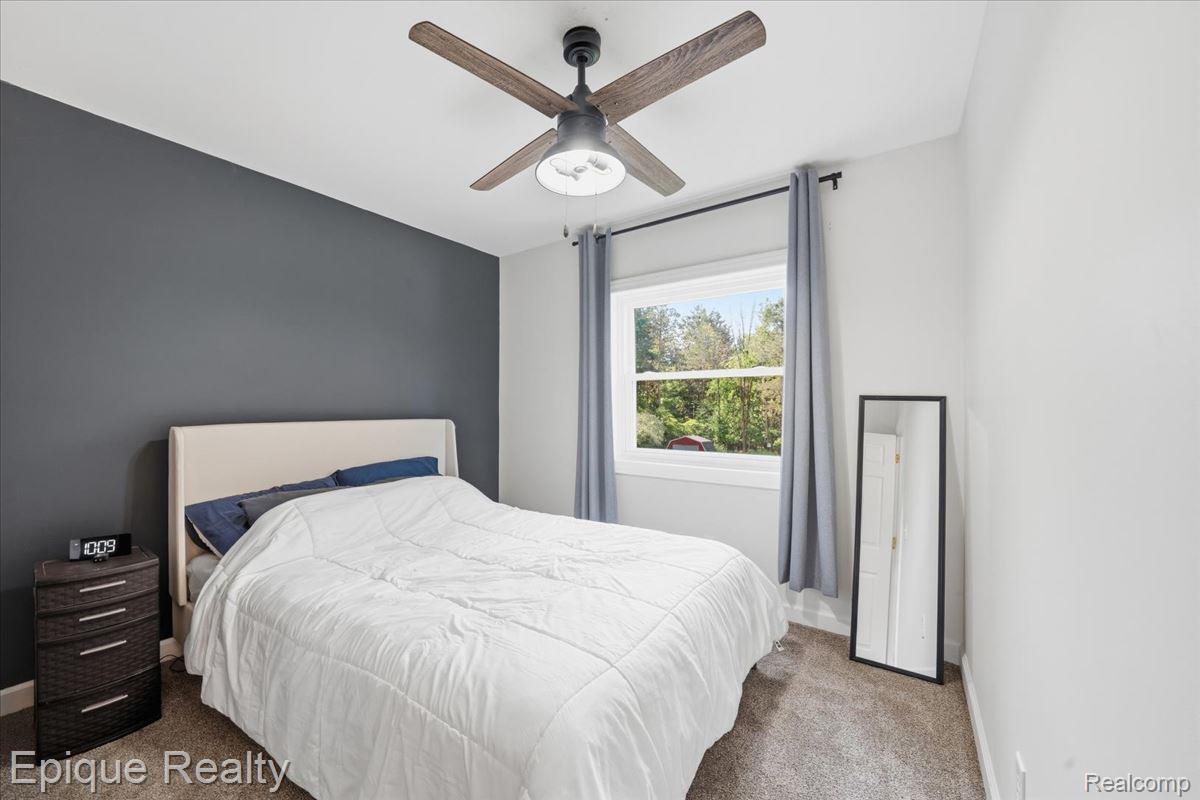 12272 East Mt Morris Road Davison, MI 48423 - Photo 18 of 39 Neutral tone walls with an accent wall and a ceiling fan with wood-finish blades