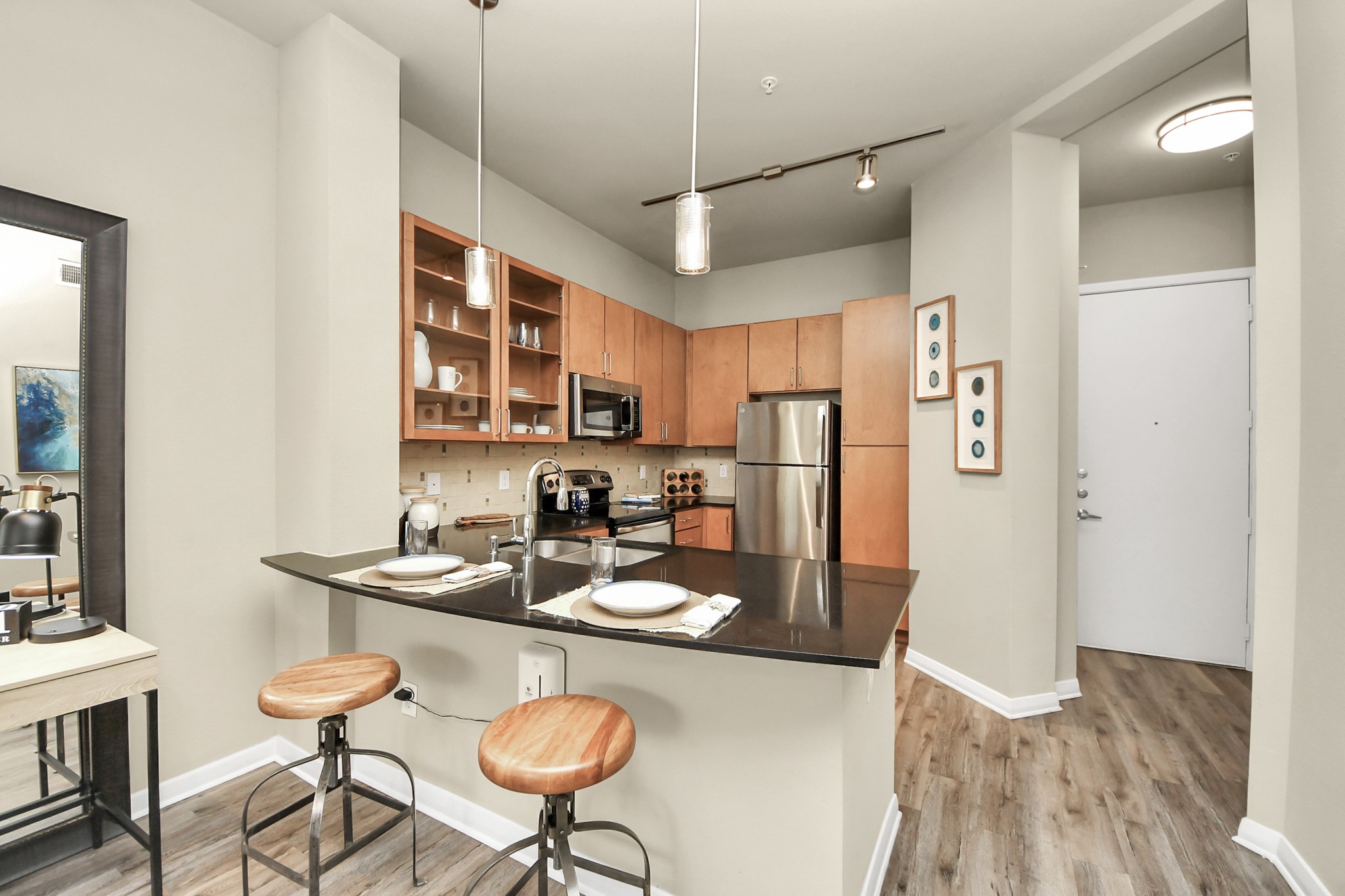 5455 Richmond Avenue, Unit 3046 Houston, TX 77056 - Photo 30 of 50 a kitchen with stainless steel appliances granite countertop a refrigerator a stove a sink dishwasher a dining table and chairs with wooden floor