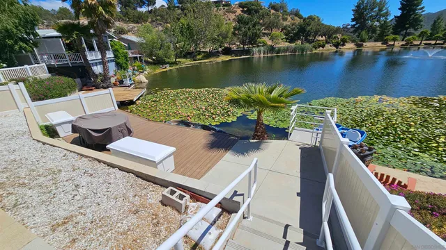 an aerial view of a house with outdoor space and a lake view in back