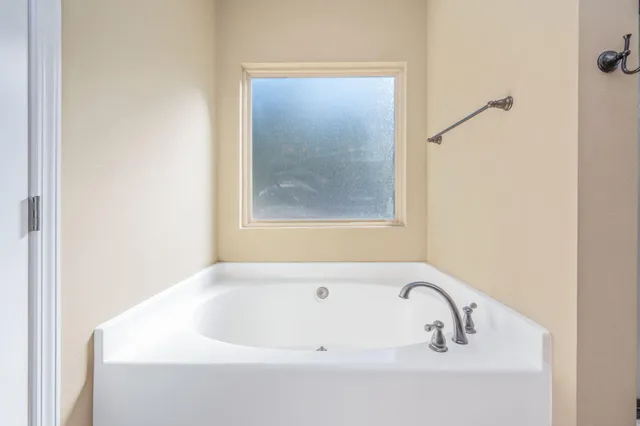 a white bath tub sitting next to a shower