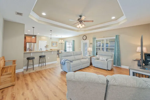 a living room with furniture and a view of kitchen