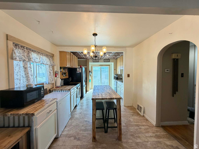 156 D Street Helper, UT 84526 - Photo 9 of 24 Kitchen featuring arched walkways, stainless steel appliances, hanging lights, and wooden counters