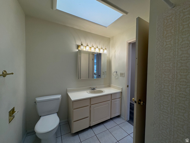595 Meadowlark Road Orem, UT 84097 - Photo 42 of 87 Bathroom featuring a skylight, white tile flooring, a single vanity with a white countertop and integrated sink, a mirrored medicine cabinet, and a five-light fixture