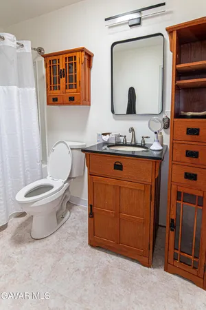 a bathroom with a toilet a sink and mirror