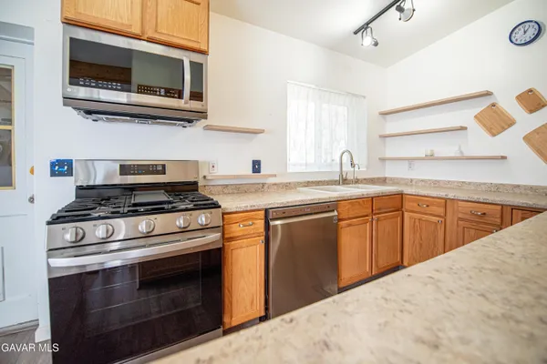 a kitchen with stainless steel appliances granite countertop a stove microwave and sink