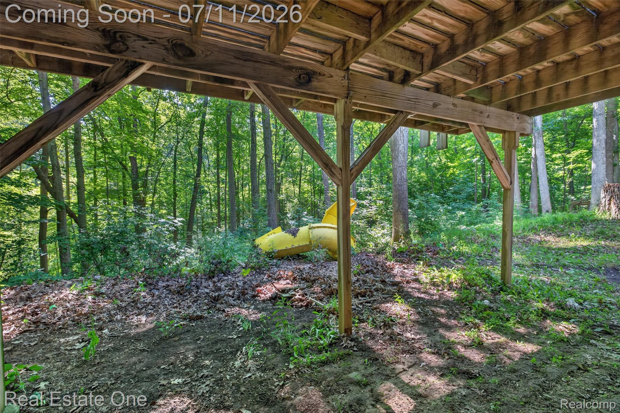 310 South Van Road Holly, MI 48442 - Photo 64 of 67 Under-deck area featuring exposed wood beams and support posts, with a natural, wooded backdrop