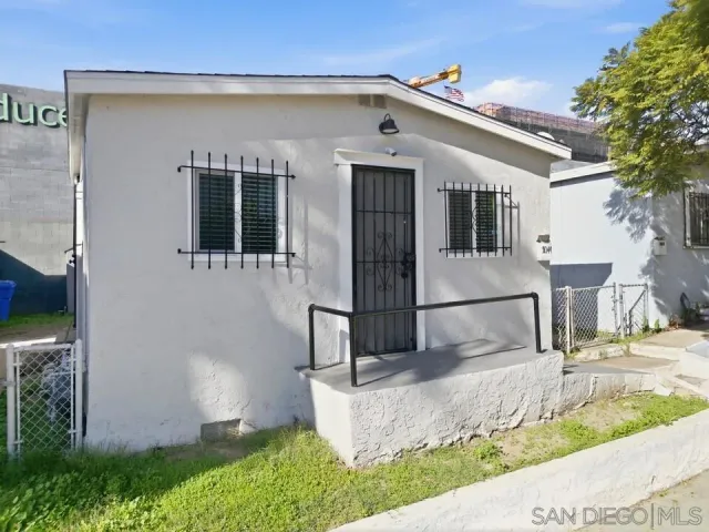 a view of a big house with large windows and plants