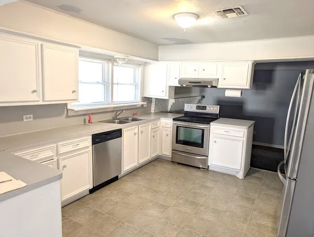 a kitchen with a stove a sink and a window