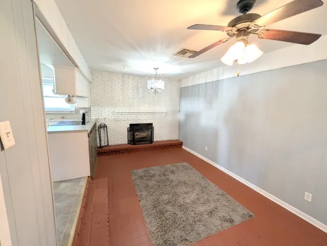 a view of kitchen and empty room with wooden floor
