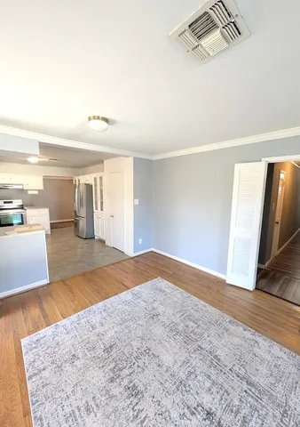 a view of empty room with wooden floor