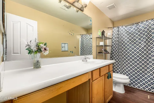 a bathroom with a granite countertop sink a toilet and mirror