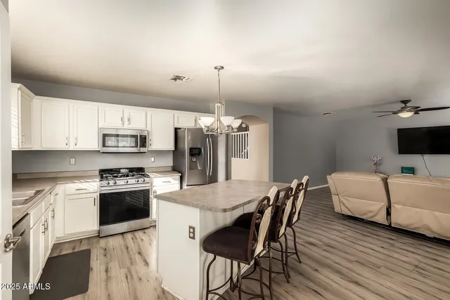 a kitchen with stainless steel appliances kitchen island granite countertop a dining table and chairs