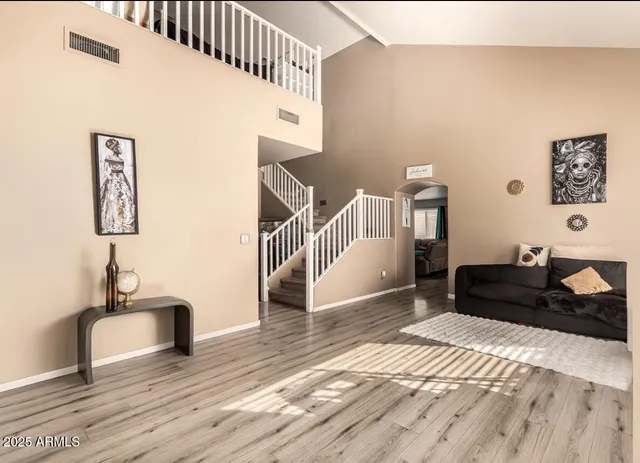 a view of a bedroom with wooden floor and stairs