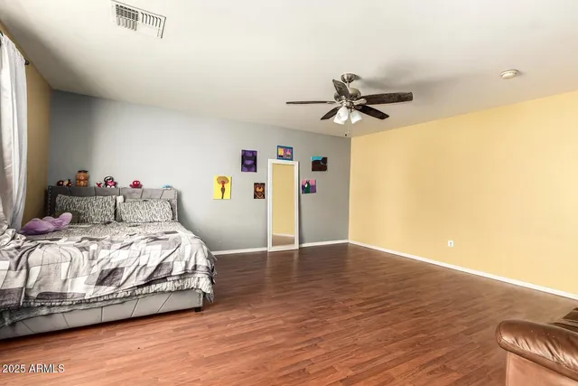 a bedroom with a bed and a ceiling fan