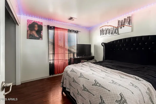 a bedroom with a bed and a flat screen tv