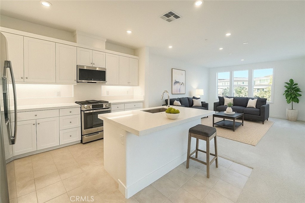 349 Proctor Irvine, CA 92618 - Photo 3 of 14 a kitchen with stainless steel appliances kitchen island granite countertop a sink and white cabinets
