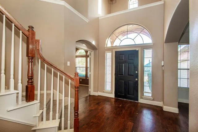 a view of a livingroom with wooden floor and stairs