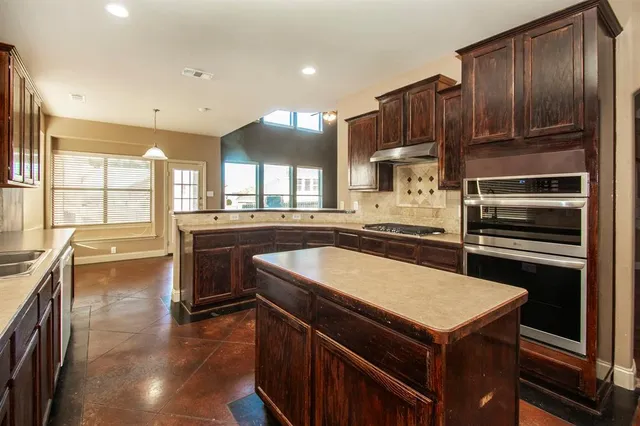 a kitchen with a stove a sink and a refrigerator