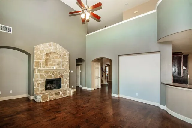 a view of an empty room with wooden floor fireplace and a window