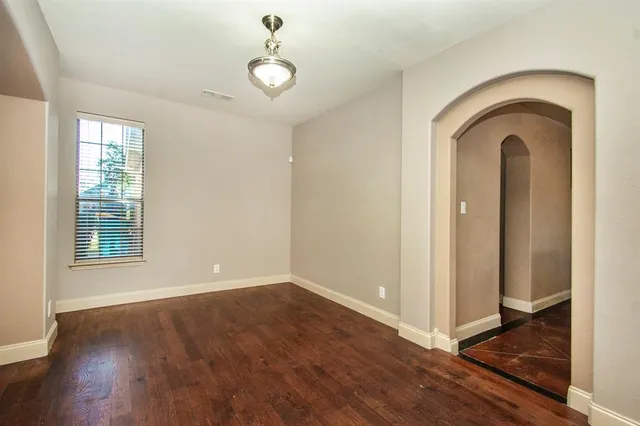 an empty room with wooden floor and window
