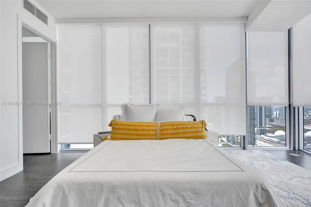 a bedroom with a large bed and a chandelier