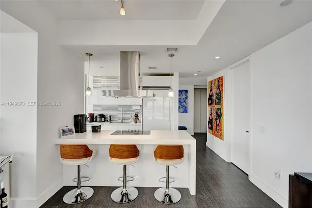 a kitchen with stainless steel appliances kitchen island granite countertop a refrigerator and microwave