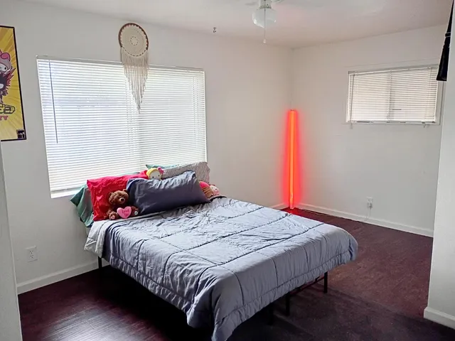 a bedroom with a bed and a wooden floor