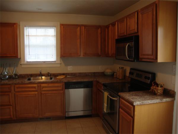 1156 Main Street Acushnet, MA 02743 - Photo 4 of 16 a kitchen with granite countertop wooden cabinets and a stove top oven