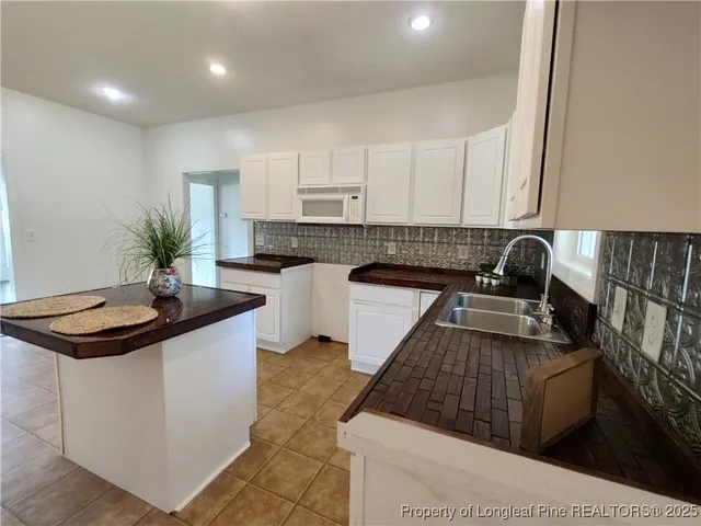 a kitchen with granite countertop a sink a stove and cabinets