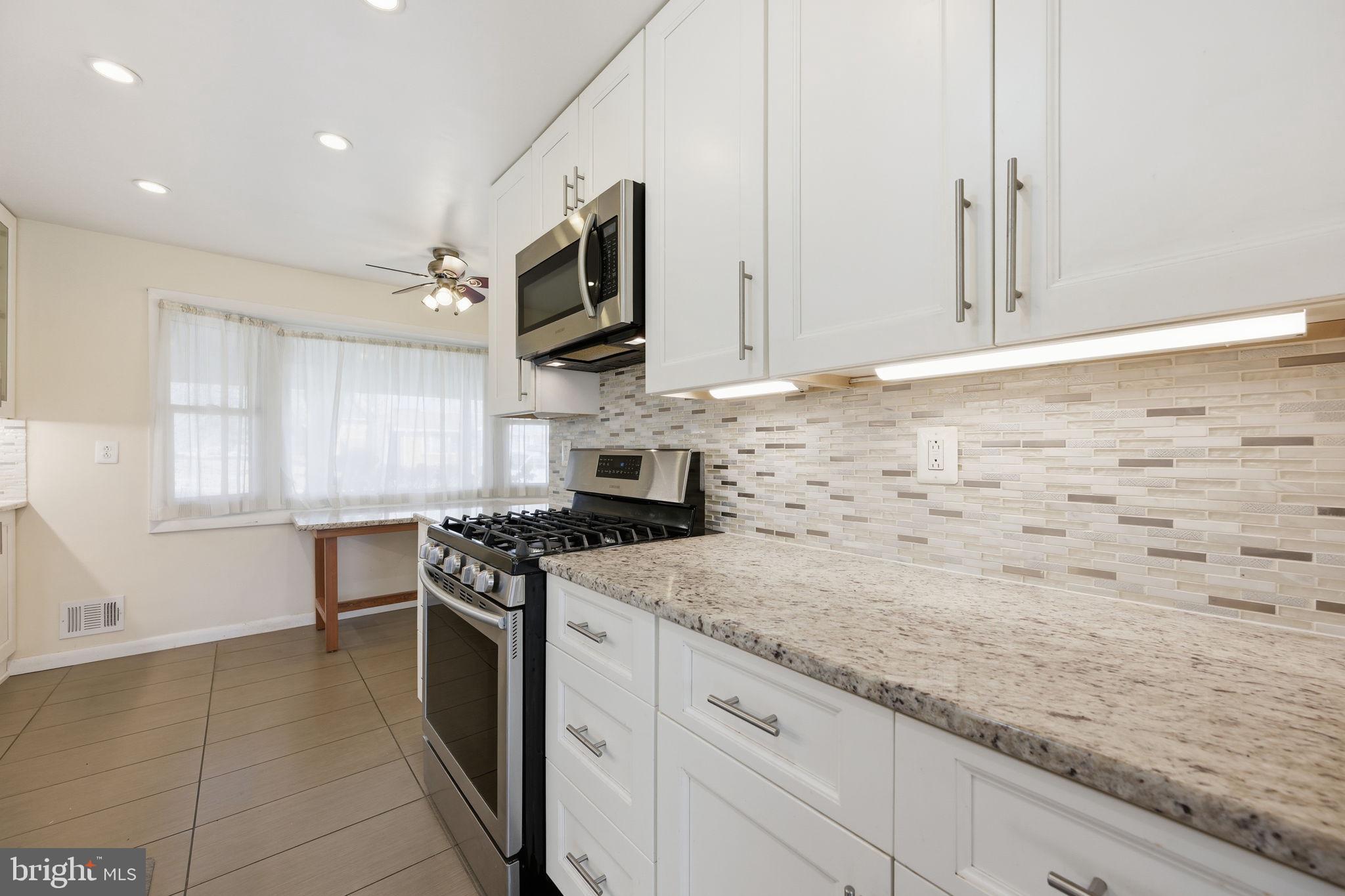 1721 University Boulevard West Silver Spring, MD 20902 - Photo 11 of 38 a kitchen with stainless steel appliances granite countertop a stove a sink and a microwave