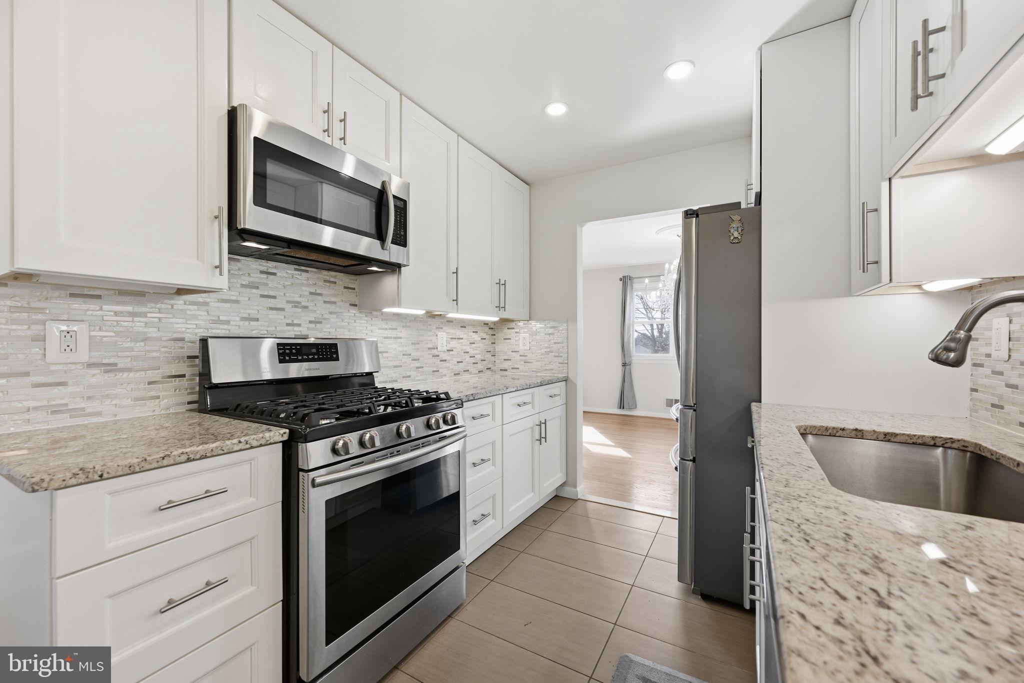 1721 University Boulevard West Silver Spring, MD 20902 - Photo 14 of 38 a kitchen with stainless steel appliances granite countertop a sink stove and refrigerator