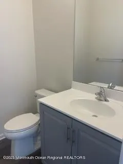 a bathroom with a granite countertop sink a toilet and shower