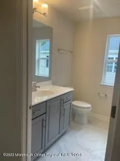 a bathroom with a toilet a sink and mirror