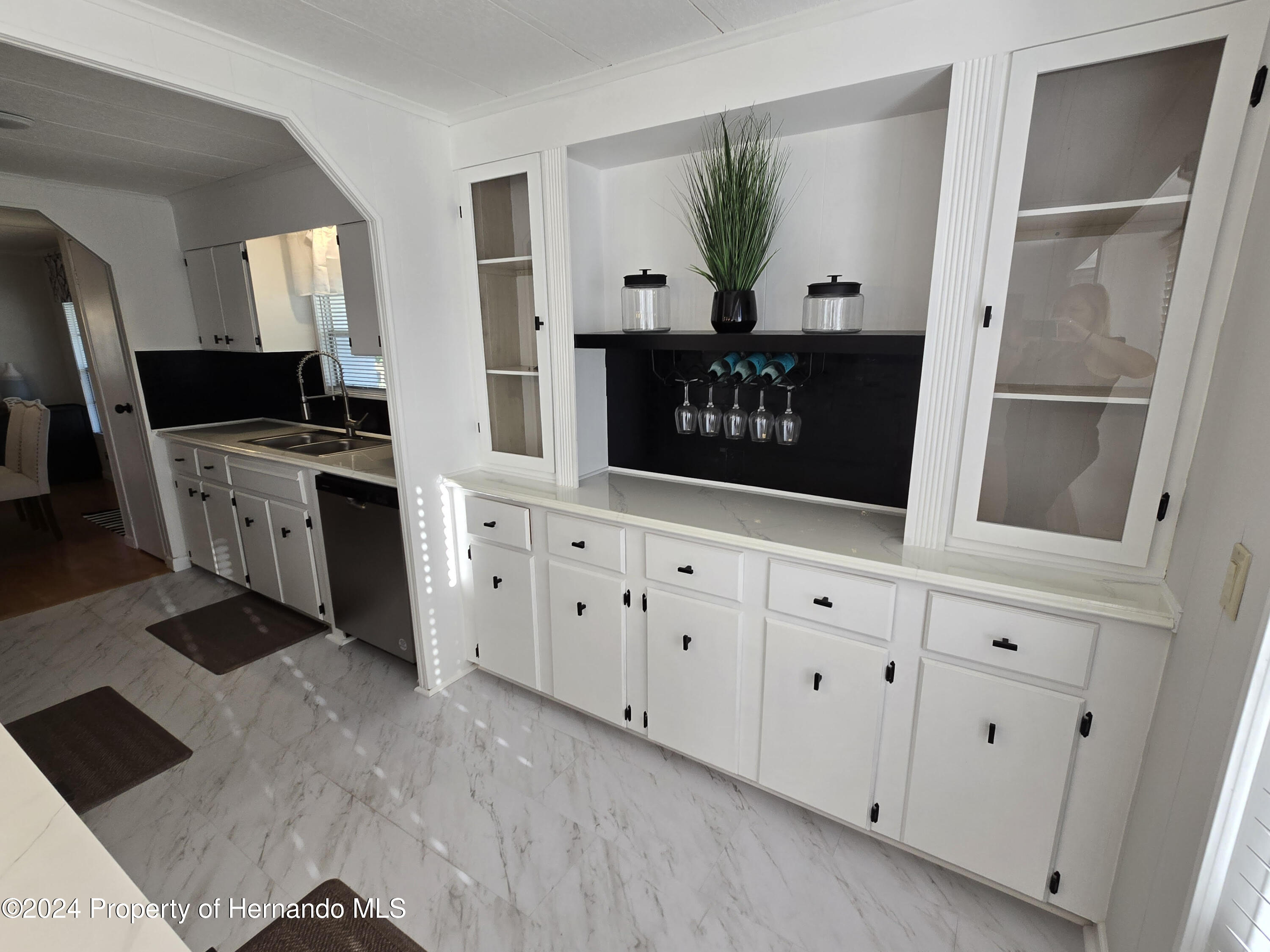 15260 Brookridge Boulevard Brooksville, FL 34613 - Photo 12 of 56 a kitchen with white cabinets and a painting on the wall