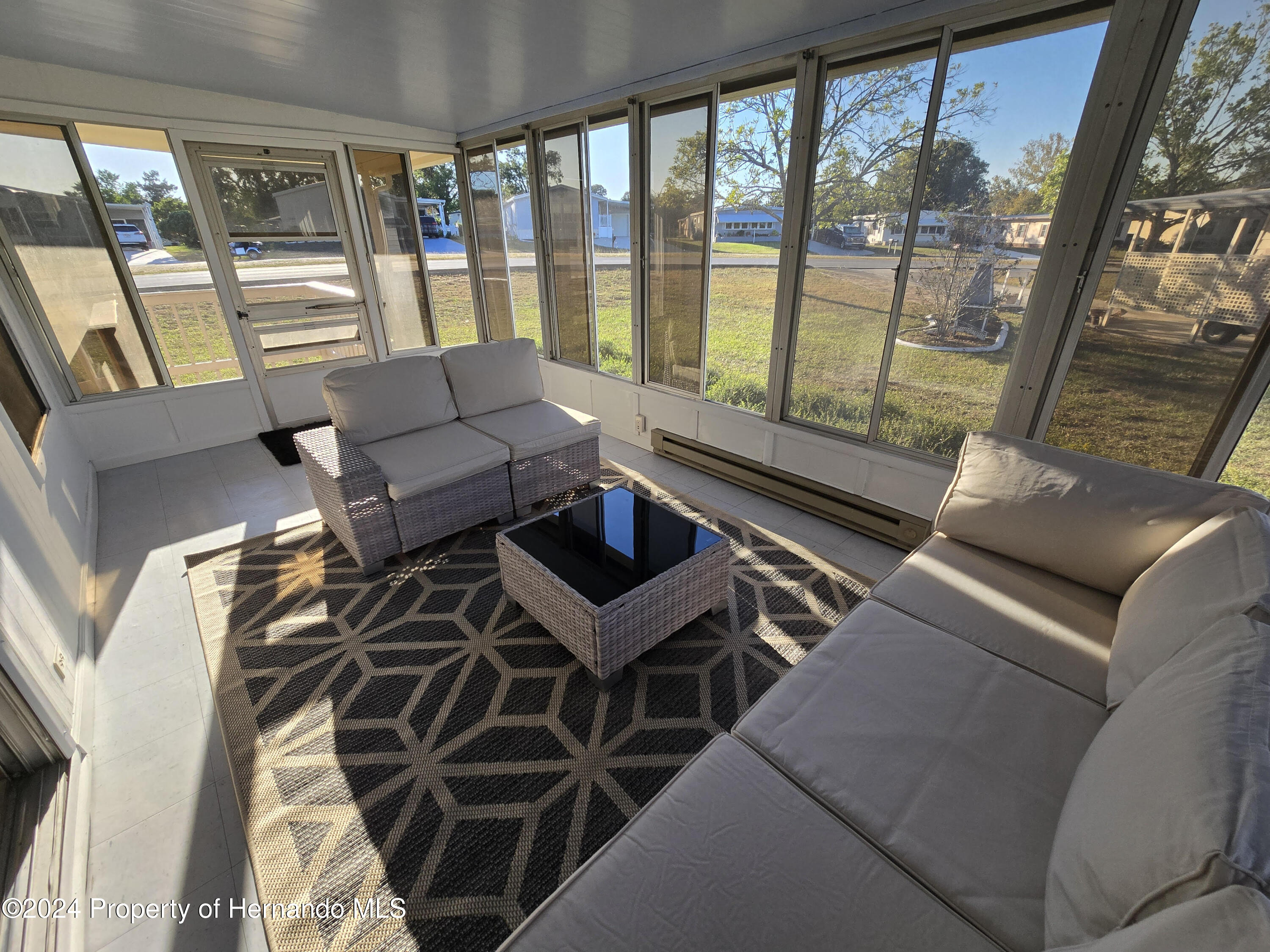 15260 Brookridge Boulevard Brooksville, FL 34613 - Photo 26 of 56 a living room with furniture and a floor to ceiling window