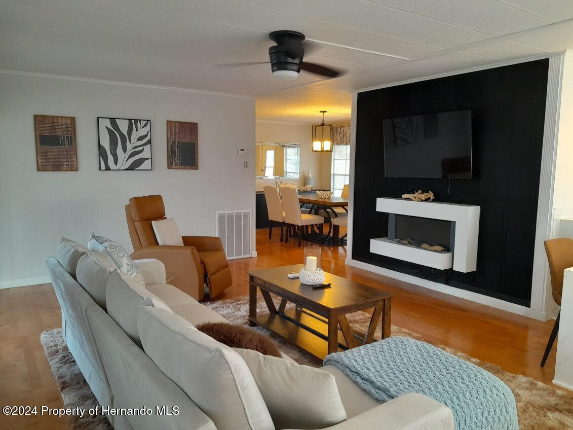 15260 Brookridge Boulevard Brooksville, FL 34613 - Photo 3 of 56 a living room with furniture and a flat screen tv