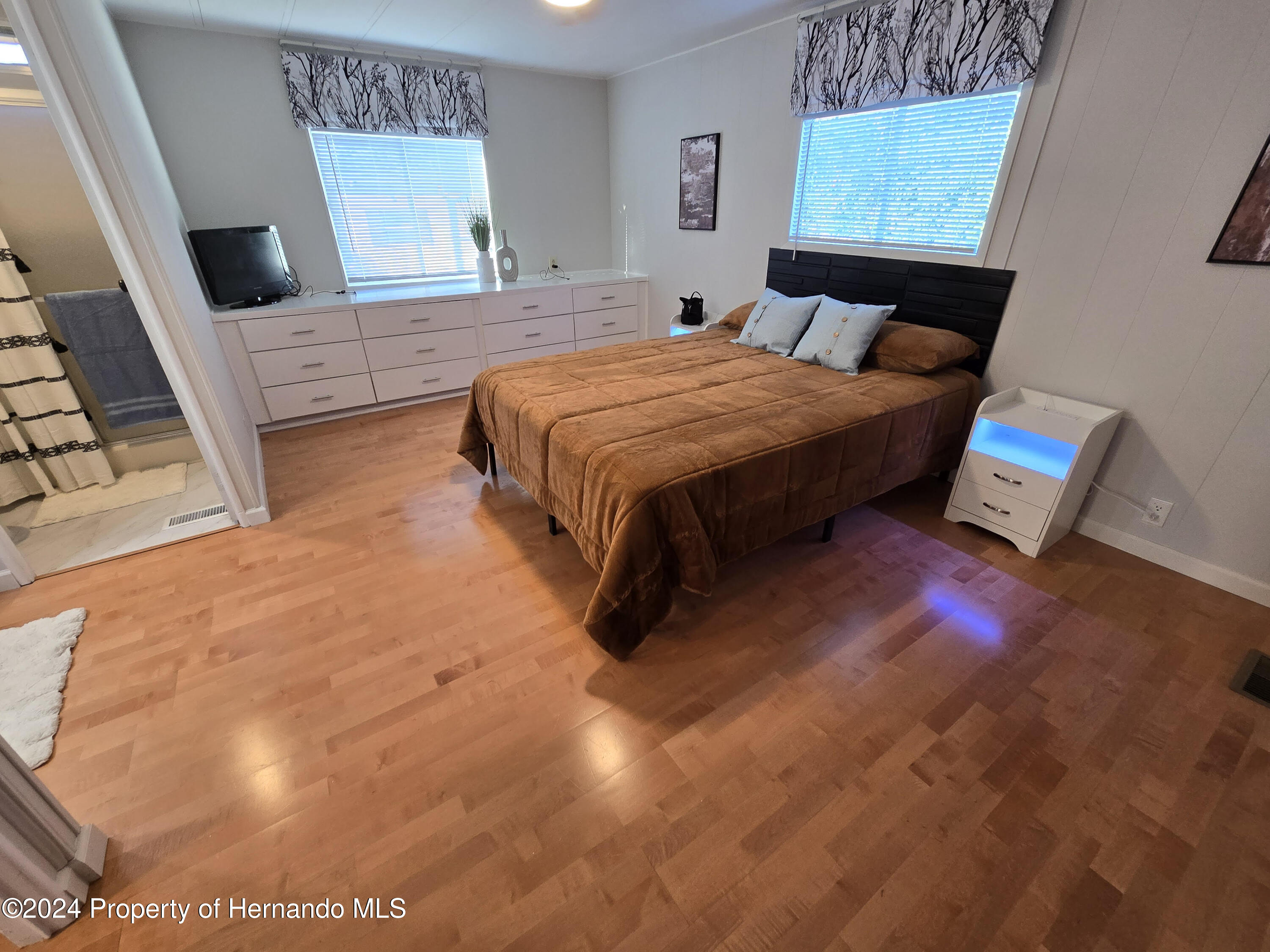 15260 Brookridge Boulevard Brooksville, FL 34613 - Photo 34 of 56 a bedroom with a bed and wooden floor