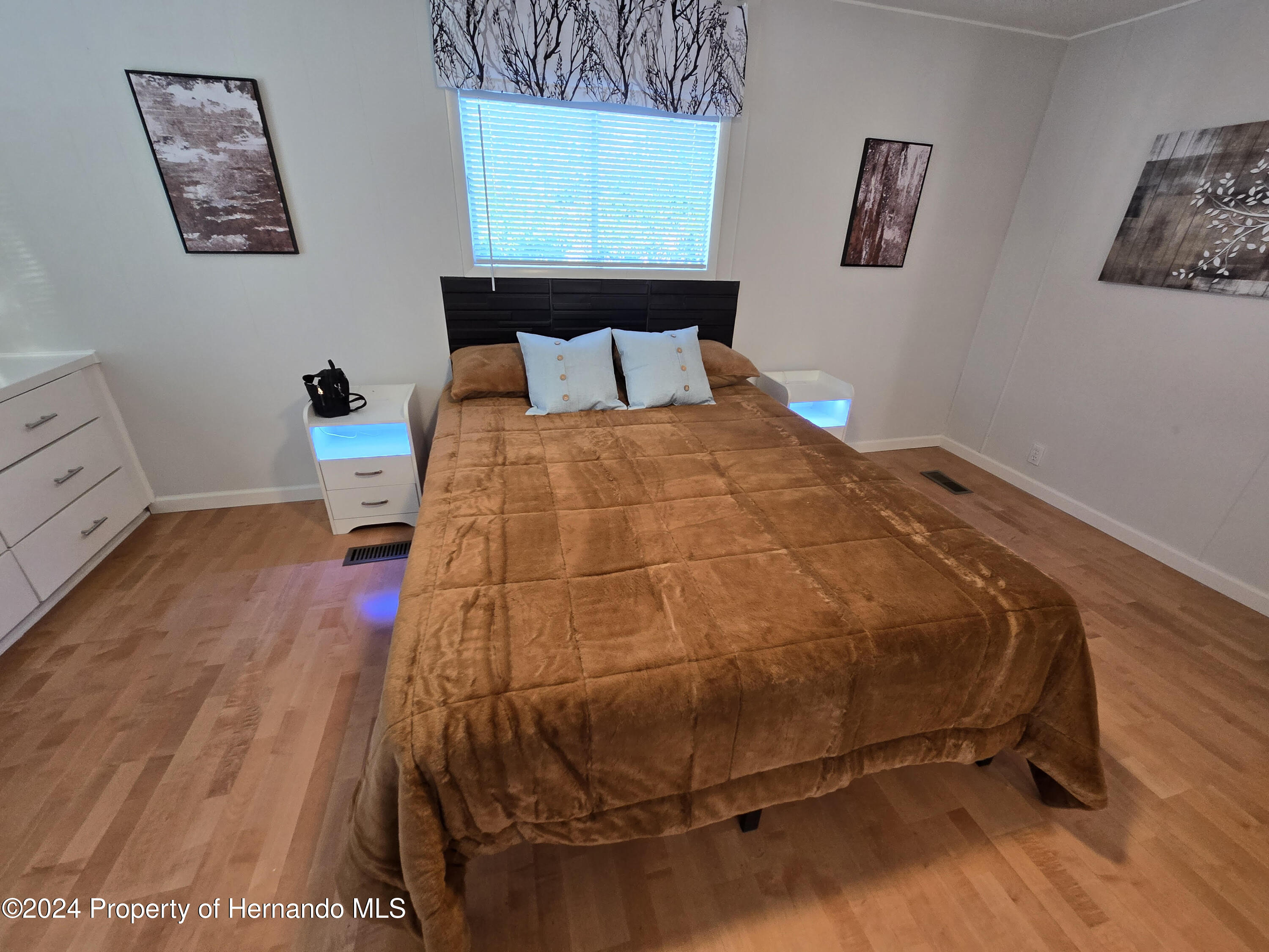 15260 Brookridge Boulevard Brooksville, FL 34613 - Photo 35 of 56 a bedroom with a bed and wooden floor