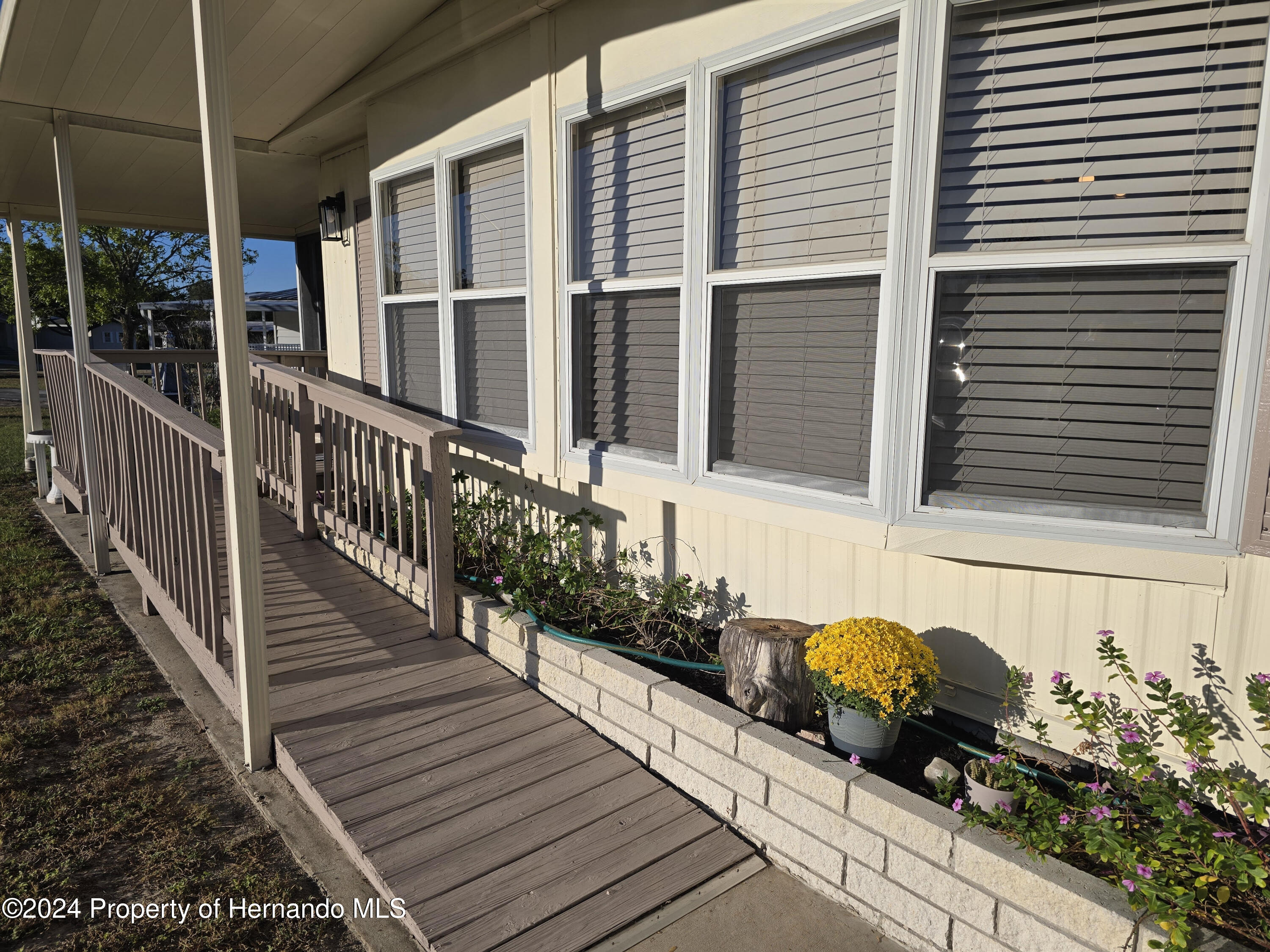 15260 Brookridge Boulevard Brooksville, FL 34613 - Photo 43 of 56 a bunch of flowers sitting in front of a house
