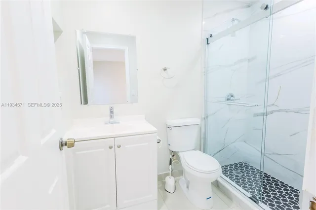 a view of a kitchen with a refrigerator and a more cabinets