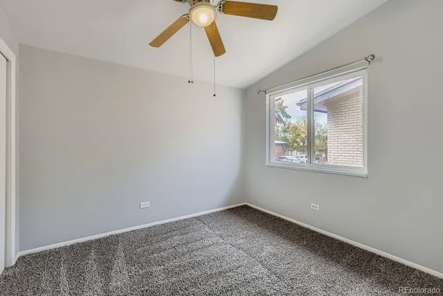 an empty room with windows and dry ceiling fan