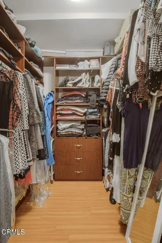 a view of walk in closet with clothes and shoes