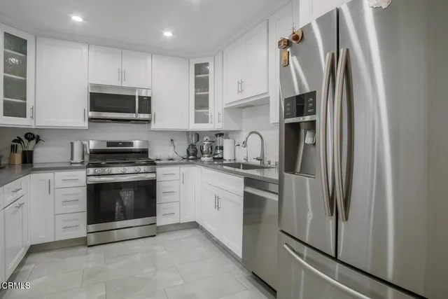 a kitchen with stainless steel appliances a refrigerator sink and microwave