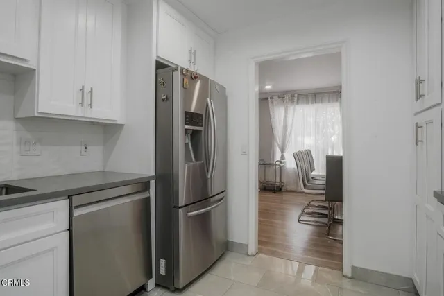 a kitchen with stainless steel appliances granite countertop a refrigerator and a sink
