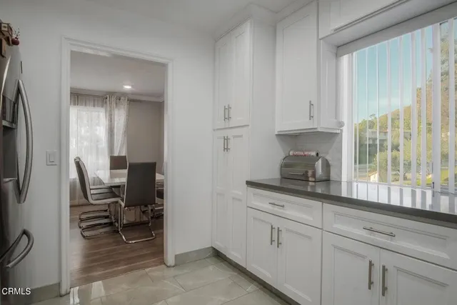 a kitchen with stainless steel appliances white cabinets and a window