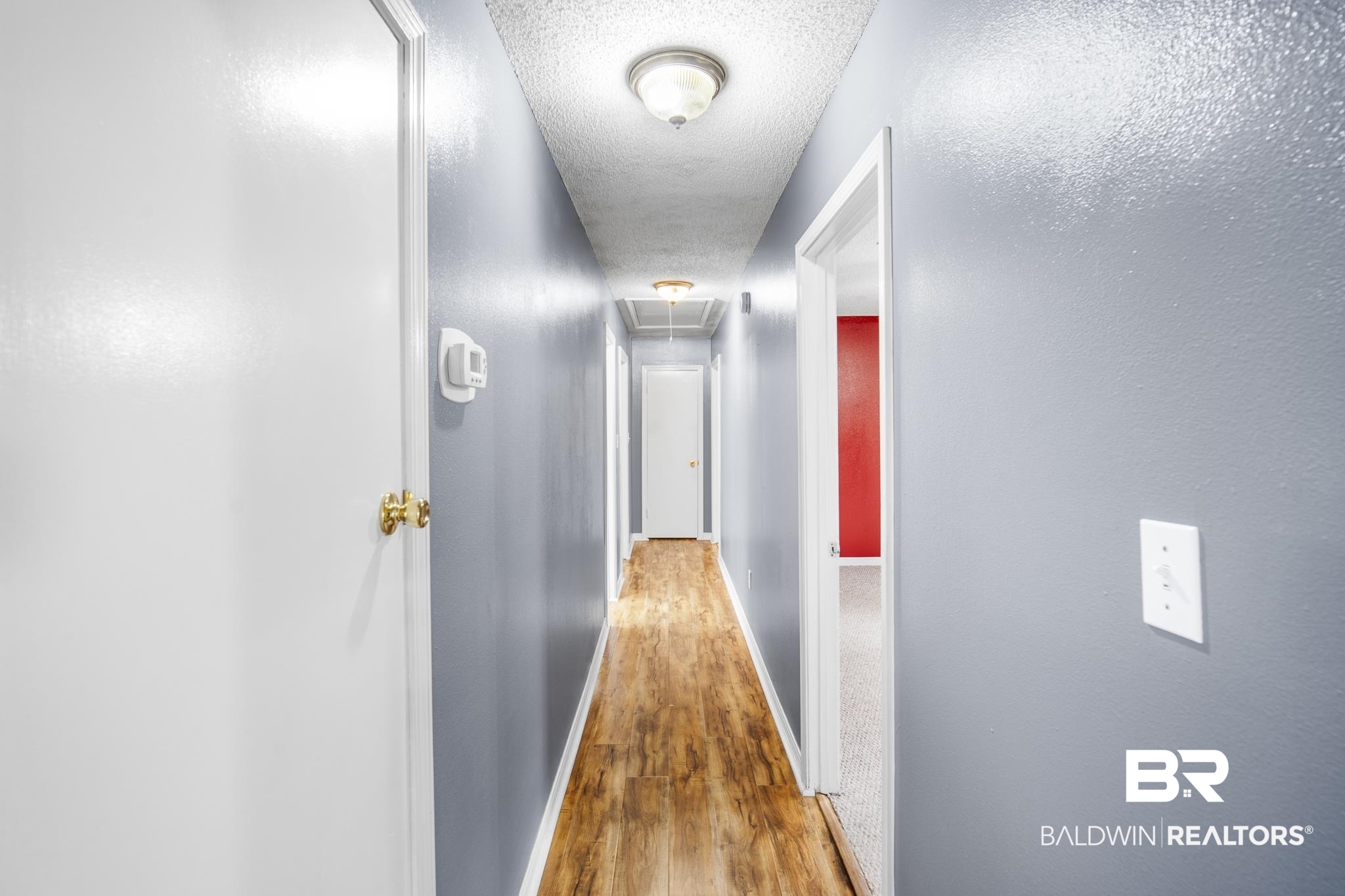 103 Ann Street Daphne, AL 36527 - Photo 9 of 23 Corridor with attic access, wood finished floors, and a textured ceiling
