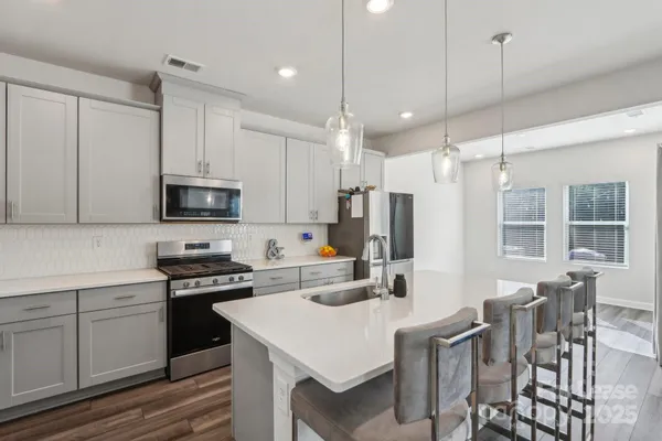 a kitchen with stainless steel appliances a stove sink microwave and refrigerator