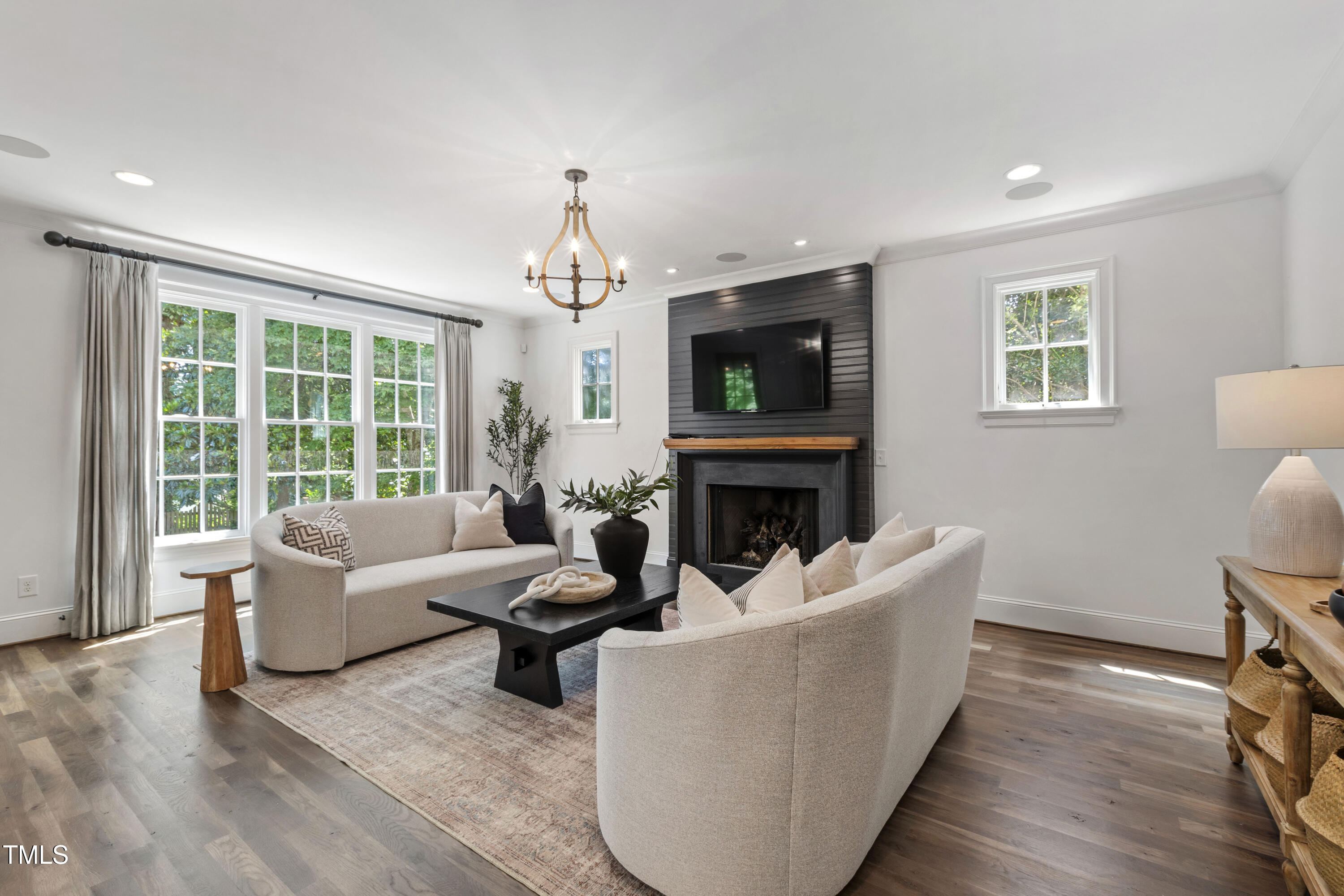 523 Vick Avenue Raleigh, NC 27612 - Photo 9 of 77 a living room with furniture a fireplace and a flat screen tv