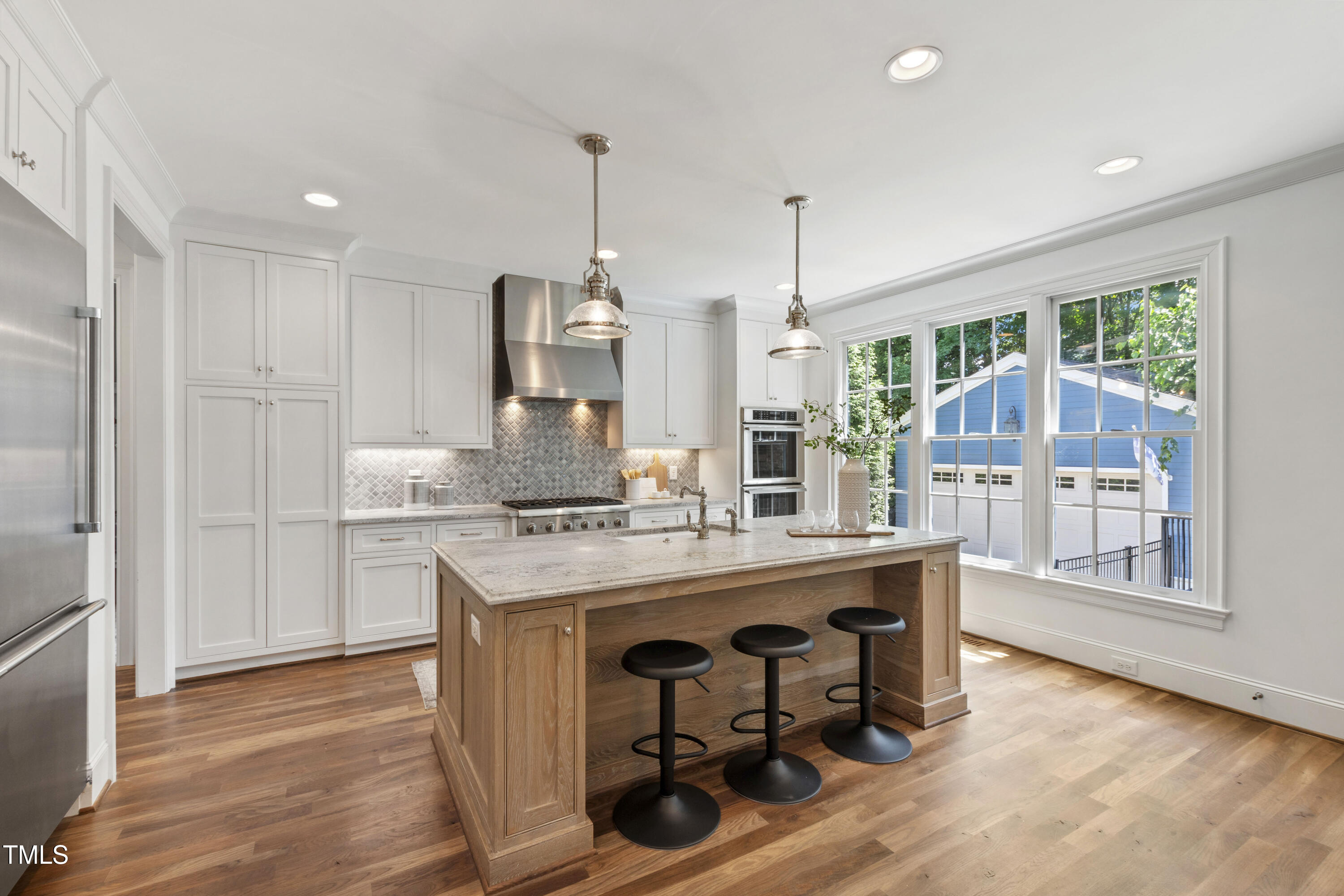 523 Vick Avenue Raleigh, NC 27612 - Photo 20 of 77 a kitchen with kitchen island a large counter top space a sink stainless steel appliances and cabinets