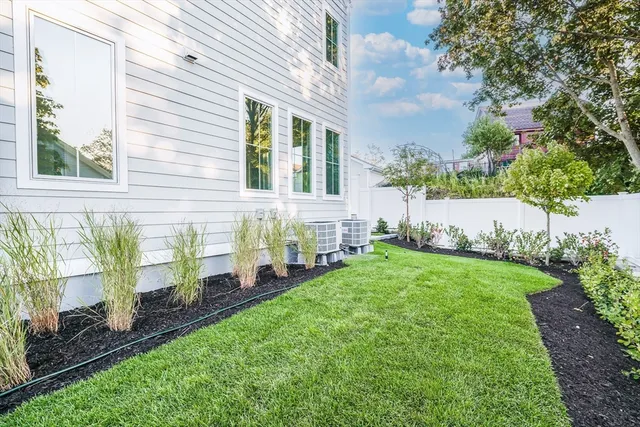 a front view of a house with a yard and potted plants